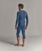 Ein Mann in einem dunkelblauen Langarmshirt und Dreiviertel-Leggings, von hinten gesehen.