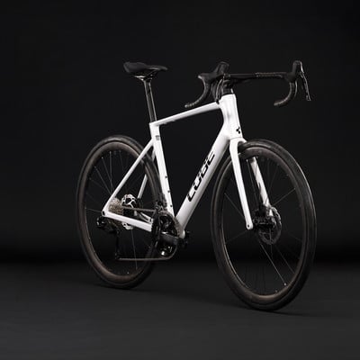 Ein weißes Cube Rennrad mit schwarzen Details auf dunklem Hintergrund. Ein weißes Cube Rennrad mit schwarzen Details auf dunklem Hintergrund.