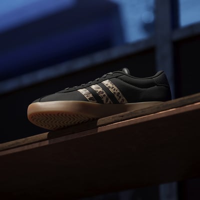 Fekete Adidas cipő leopárdmintás csíkokkal az oldalán.