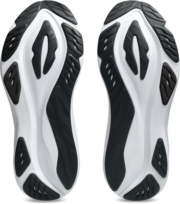 Blick auf die Sohlen zweier Sportschuhe im weißen und schwarzen Design. Blick auf die Sohlen zweier Sportschuhe im weißen und schwarzen Design.