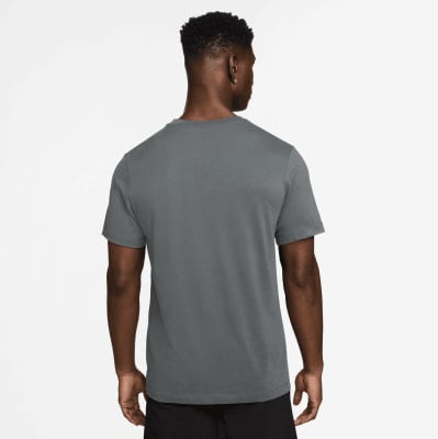 Ein Mann in einem dunkelgrauen T-Shirt mit kurzen Ärmeln und schwarzen Shorts. Ein Mann in einem dunkelgrauen T-Shirt mit kurzen Ärmeln und schwarzen Shorts.