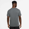 Ein Mann in einem dunkelgrauen T-Shirt mit kurzen Ärmeln und schwarzen Shorts.