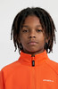 Ein Junge mit Dreadlocks trägt eine orangefarbene Jacke mit O'Neill-Logo.