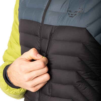 Ein Mann schließt eine schwarze Daunenjacke mit einem blau-grünen Streifen oben. Ein Mann schließt eine schwarze Daunenjacke mit einem blau-grünen Streifen oben.