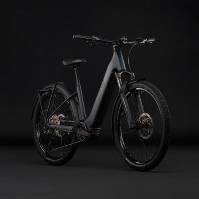 Modernes dunkelgraues E-Bike mit Federung und Schutzblechen.
