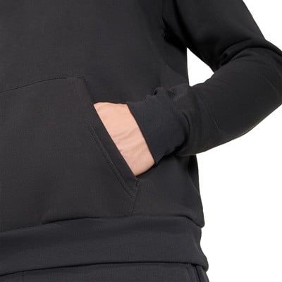 Eine Hand steckt in der Tasche eines schwarzen Hoodies. Eine Hand steckt in der Tasche eines schwarzen Hoodies.