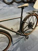 Schwarzes Fahrrad mit Gepäckträger und braunen Reifen auf blauem Teppich.
