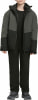 Junge in dunkler Winterjacke und Hose mit Schuhen.