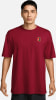 Ein Mann in einem dunkelroten T-Shirt mit Nike-Logo auf der Brust.