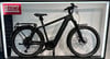 Schwarzes E-Bike von Riese & Müller mit Gepäckträger und Schutzblechen.