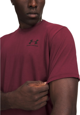 Ein Mann in einem dunkelroten T-Shirt mit Under Armour-Logo. Ein Mann in einem dunkelroten T-Shirt mit Under Armour-Logo.