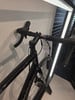 Schwarzes Rennrad mit Lenker und Bremshebeln vor weißem Hintergrund.