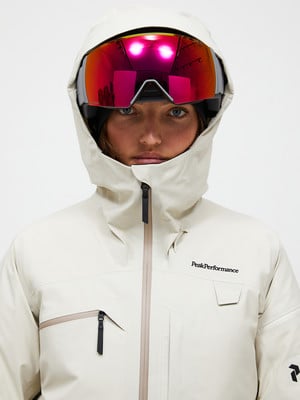 Skifahrerin in weißer Jacke und roter Brille blickt in die Kamera. Skifahrerin in weißer Jacke und roter Brille blickt in die Kamera.