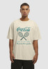 Ein Mann in einem beigefarbenen T-Shirt mit Coca-Cola-Logo und Tennisschlägern.