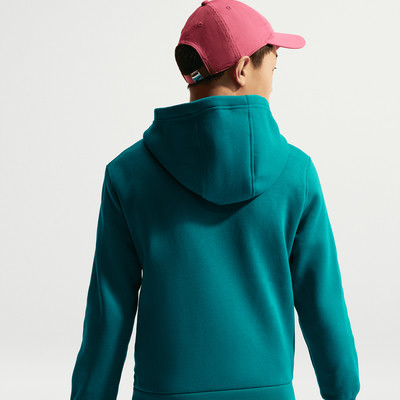 Rückansicht einer Person im dunkel-türkisfarbenen Kapuzenpullover und einer rosa Kappe.
