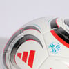 Detail eines Adidas-Fußballs mit rotem Logo und blauen Mustern.