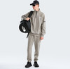 Ein Mann in einem grauen Anzug mit einer schwarzen Umhängetasche.