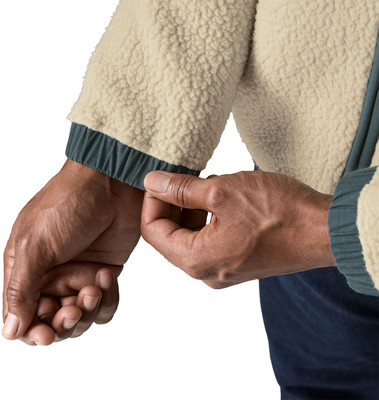 Detail einer Hand, die den Ärmelsaum einer Fleecejacke anpasst. Detail einer Hand, die den Ärmelsaum einer Fleecejacke anpasst.