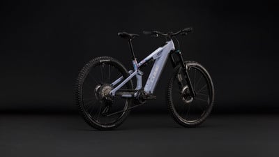 Graues Cube E-Mountainbike mit schwarzen Rädern vor dunklem Hintergrund. Graues Cube E-Mountainbike mit schwarzen Rädern vor dunklem Hintergrund.