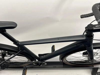 Ein schwarzes Fahrrad mit einem tropfenförmigen Rahmen und einem schwarzen Lenker ist ausgestellt.
