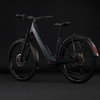 Dunkelblaues Cube E-Bike mit Schutzblechen und Gepäckträger vor schwarzem Hintergrund.