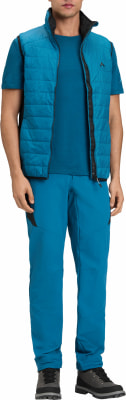 Ein Mann in einer blauen Weste, einem T-Shirt und einer Hose mit Wanderschuhen. Ein Mann in einer blauen Weste, einem T-Shirt und einer Hose mit Wanderschuhen.