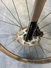 Detail einer vorderen Scheibenbremse eines Fahrrads mit schwarzer Gabel.