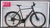 Schwarzes E-Bike mit Schutzblechen und Gepäckträger vor weißem Hintergrund.