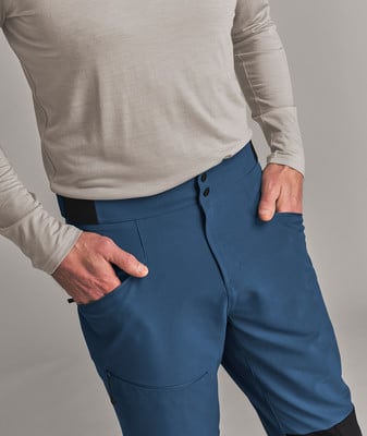 Ein Mann in blauen Hosen und einem beigen Hemd hat die Hände in den Taschen. Ein Mann in blauen Hosen und einem beigen Hemd hat die Hände in den Taschen.