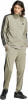 Mann in beiger Adidas-Trainingshose mit schwarzen Streifen und schwarzen Turnschuhen.