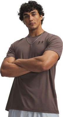 Ein Mann mit lockigem Haar trägt ein braunes T-Shirt mit Under Armour Logo. Ein Mann mit lockigem Haar trägt ein braunes T-Shirt mit Under Armour Logo.