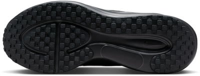 Pohled na černou podrážku boty s mřížkovaným vzorem a logem Nike.