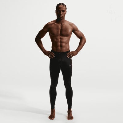 Ein Mann mit definierten Bauchmuskeln trägt schwarze Nike Sporthosen.