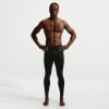 Ein Mann mit definierten Bauchmuskeln trägt schwarze Nike Sporthosen.