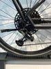 Eine SRAM-Schaltwerk an einem schwarzen Fahrrad mit Kassette.