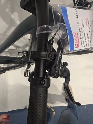 Detail des Lenkers mit Preisschild und Bremshebel an einem E-Bike. Detail des Lenkers mit Preisschild und Bremshebel an einem E-Bike.
