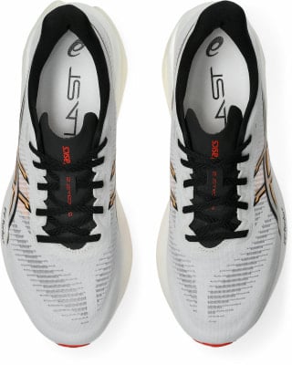 Draufsicht auf weiße Laufschuhe mit schwarzen Schnürsenkeln und orangefarbenen Details. Draufsicht auf weiße Laufschuhe mit schwarzen Schnürsenkeln und orangefarbenen Details.