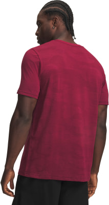 Ein Mann in einem dunkelroten T-Shirt mit kurzen Ärmeln und einer schwarzen Hose. Ein Mann in einem dunkelroten T-Shirt mit kurzen Ärmeln und einer schwarzen Hose.