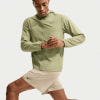 Ein Mann in einer grünen Jacke und beige Shorts mit Nike-Logo.