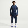 Mann in dunkelblauem Nike Trainingsanzug mit blauem Kragen und weißem Logo.