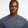 Ein Mann in einem hellblauen Nike-Shirt mit feinem Muster.