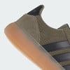 Detail tenisky Adidas s gumovou podrážkou a semišovými prvky v khaki barvě.