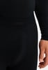 Detail schwarzer Kleidung mit Textur und Hand im Vordergrund.