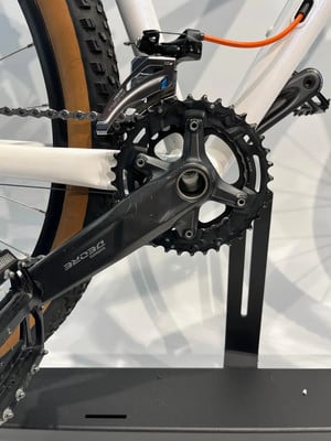 Umwerfer an einem weißen Fahrrad mit schwarzer Kurbel und Kette. Umwerfer an einem weißen Fahrrad mit schwarzer Kurbel und Kette.