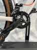 Umwerfer an einem weißen Fahrrad mit schwarzer Kurbel und Kette.