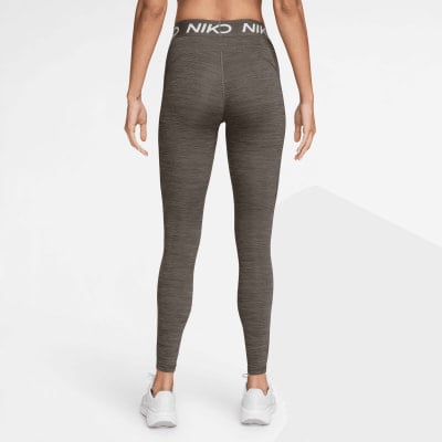 Eine Frau in dunklen Leggings und weißen Turnschuhen mit Nike-Logo am Bund.