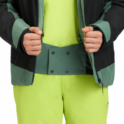 Detail einer Winterjacke und Hose mit Händen in den Taschen, grün und schwarz. Detail einer Winterjacke und Hose mit Händen in den Taschen, grün und schwarz.