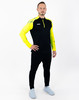 Ein Mann in einem schwarzen Langarmshirt mit gelben Akzenten und schwarzer Hose.
