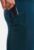 Detail einer Hand, die ein Paket in die Tasche einer dunkelblauen Sportleggings steckt.