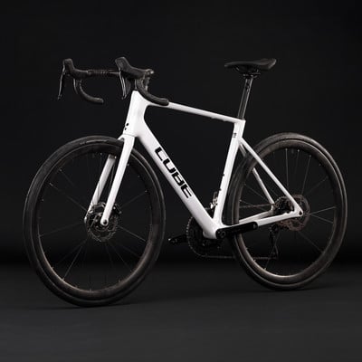 Ein weißes Cube Rennrad mit schwarzen Details auf dunklem Hintergrund. Ein weißes Cube Rennrad mit schwarzen Details auf dunklem Hintergrund.
